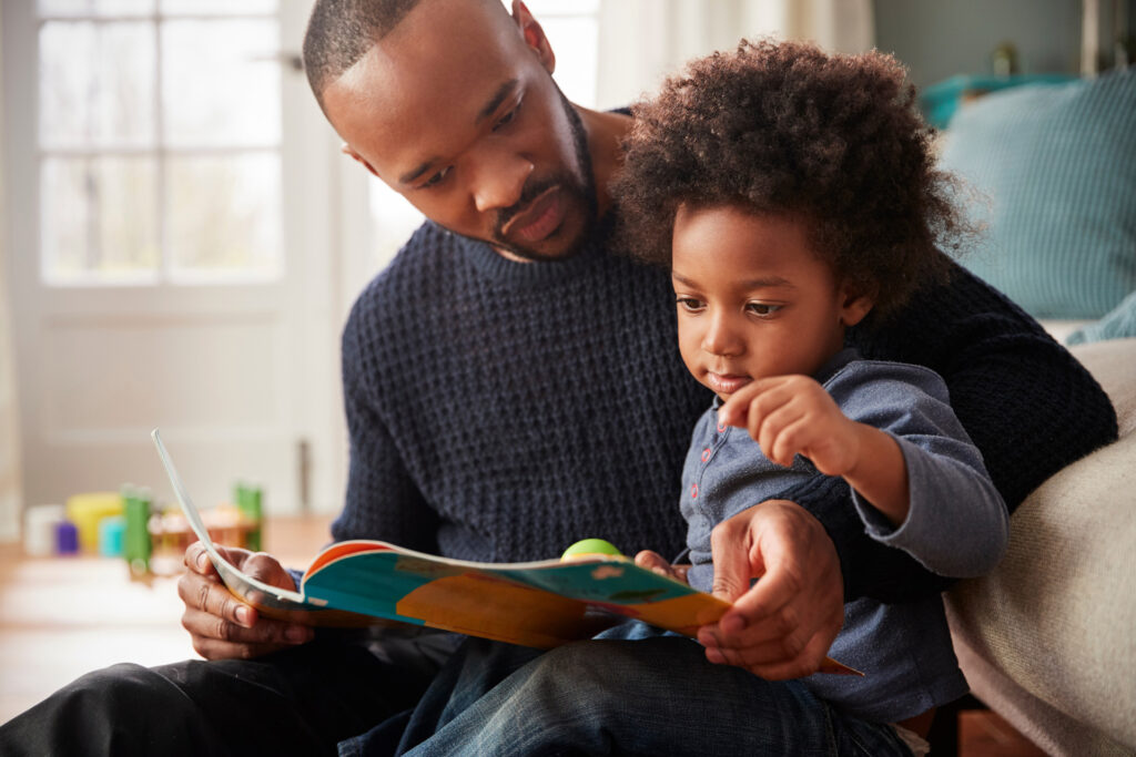 A father reads a book with a child