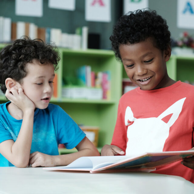 Two young students looking through a book