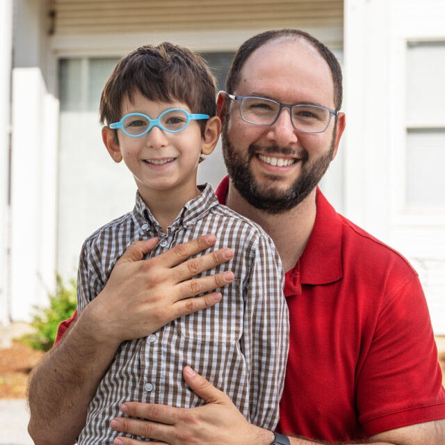 A father and his son, who is a Stern Center student, stand outside of the Stern Center building