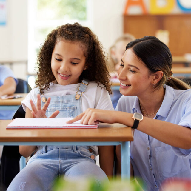 Teacher helps a student in an elementary classroom.