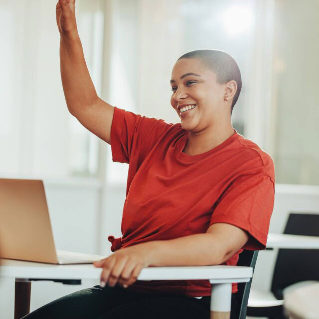 Student raising hand in a classroom