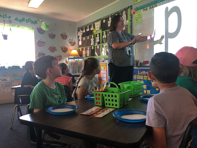 teacher in front of students teaching the letter P